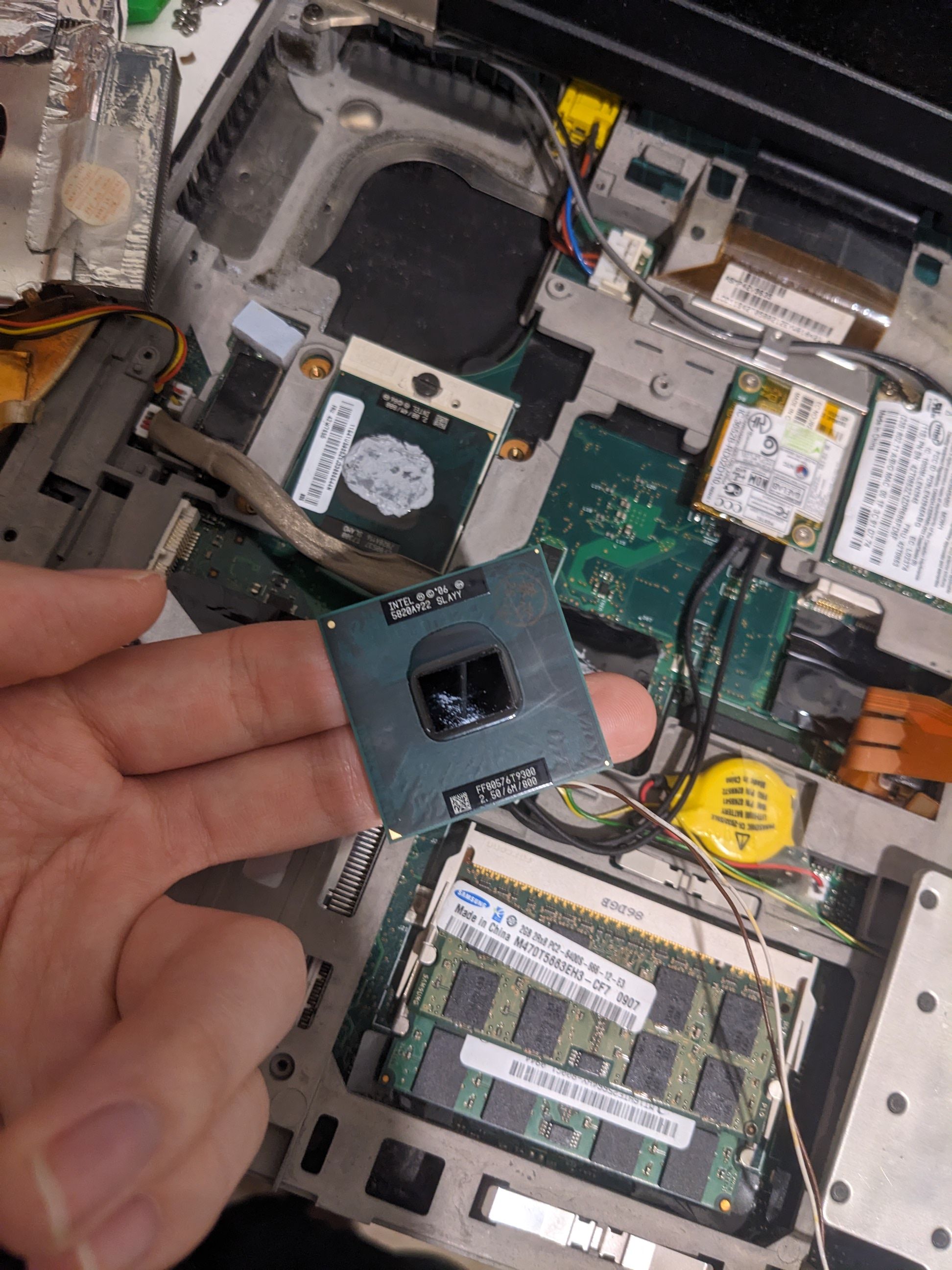 photo of me photoing the new thinkpad cpu over the open guts of the thinkpad